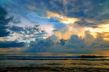 sunlight cuts through storm clouds at sunset on ocean Sri Lanka