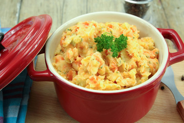 mashed carrots and potatoes on a wooden table