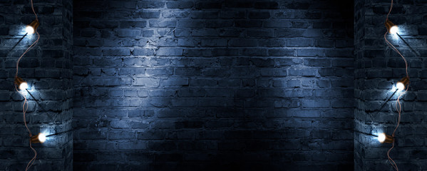 Obraz premium Dark street, old brick wall decorated with night lanterns. Empty street scene, neon light. Night view, blurred abstract bokeh light.