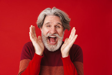 Portrait of mustached gray-haired old man in sweater screaming at camera