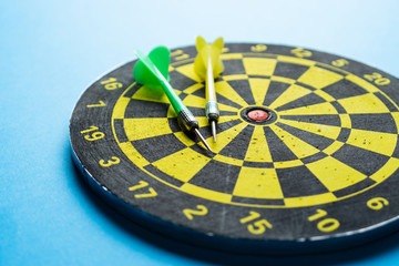 Side view of a target and darts for playing on a blue background