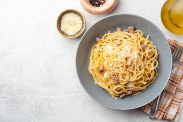 Classic spaghetti pasta carbonara with pancetta, egg yolk and parmesan cheese on concrete background. Top view, copy space.