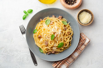 Classic spaghetti pasta carbonara with pancetta, egg yolk and parmesan cheese on concrete background. Top view.