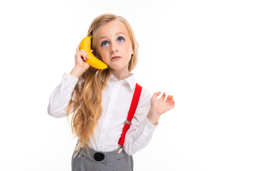 European girl speaks on a banana like on the phone on a white background