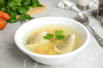 Delicious fish soup served on marble table