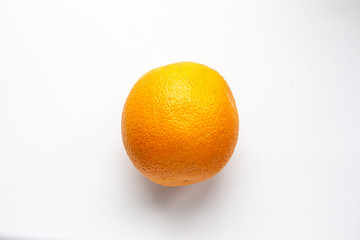 Single orange in the center on a white background, top view, flat lay