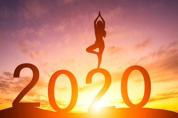 Happy New Year 2020, Silhouette woman practicing yoga early morning sunrise over the horizon background, Health and Happy new year concept.