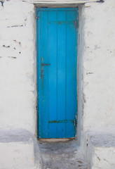 Santorini Greece scene of light blue wooden door in white stone house