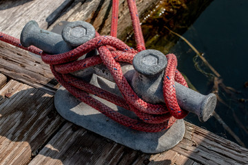 Marina dock cleat with red and blue line tied to it