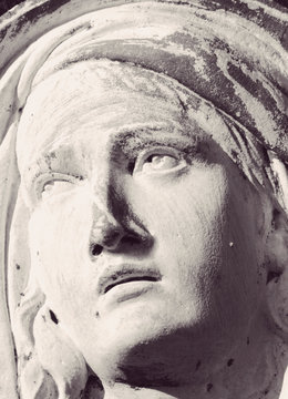 Close up face of Virgin Mary as a symbol of love and kindness. Fragment of ancient statue.