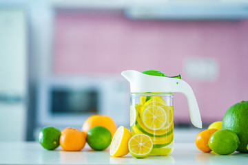 Glass jug with refreshing infused detoxification citrus water for vitamin detox drink. Slimming antioxidant drinks for diet healthy drinking