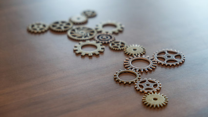 Connecting gears on wooden table. Fulfill and fix the problem of incomplete teamwork.