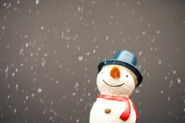 Happy smiley snowman wear blue hat and carrot nose standing with snowflakes in winter christmas season.Black background.Christmas scenes.