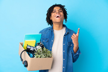 Young African American man making a move while picking up a box full of things pointing up a great...