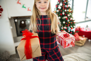 Young happy girl holding two christmas presents