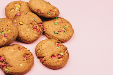 Oatmeal cookies with colorful drops on a pink background copy space.