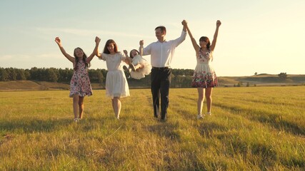 concept of a happy family. Children and mom are playing in meadow. mother and little daughter with sisters walking in park. Happy young family with child walking on summer field. happy family concept