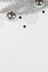 Christmas composition with silver tree branches, snowflakes and balls on white background