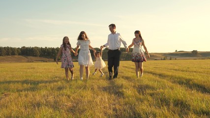 Fototapeta na wymiar concept of a happy family. Children and mom are playing in meadow. mother and little daughter with sisters walking in park. Happy young family with child walking on summer field. happy family concept