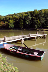 Naklejka na ściany i meble Wooden boat on the shore of the lake