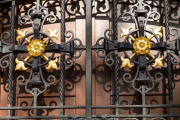 Shod, black, a lattice closes a wooden door.