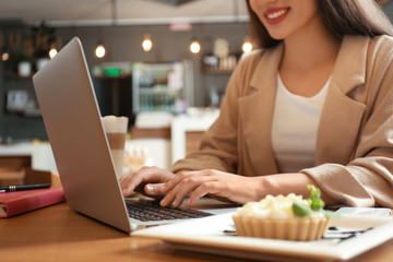 Blogger working with laptop in cafe, closeup