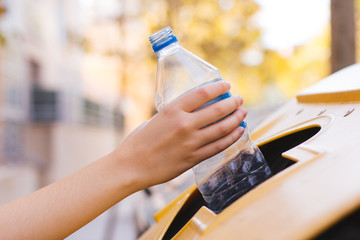 Stock photo of a woman's hand recycling a plastic bottle