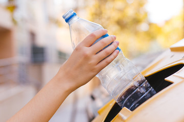 Stock photo of a woman's hand recycling a plastic bottle