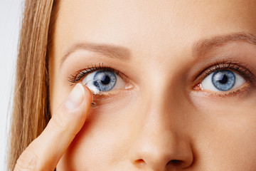 Young woman puts contact lens in her eye. Eyewear, eyesight and vision, eye care and health, ophthalmology and optometry concept