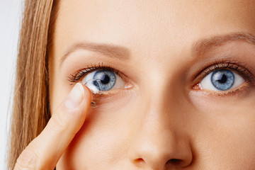 Young woman puts contact lens in her eye. Eyewear, eyesight and vision, eye care and health,...