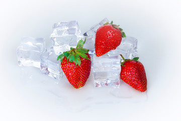 Ripe red strawberries on a background of ice cubes.