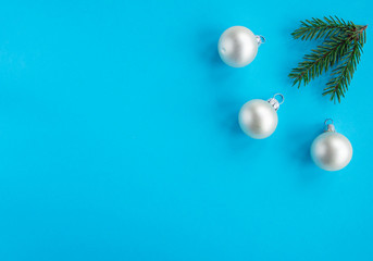 Christmas New year flat lay with pine tree, silver balls and branch on blue background. Greeting card, top view, copy space. 