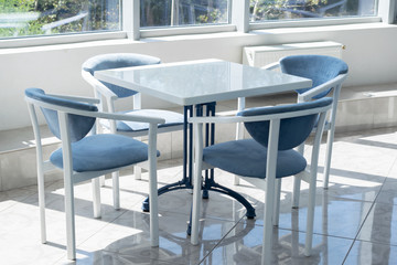 Carolina blue and white table and chairs set on a terrace. 