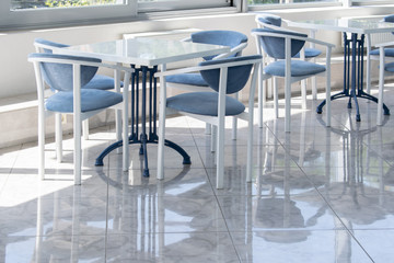 Carolina blue and white table and chairs sets on a terrace. White tile floor. 