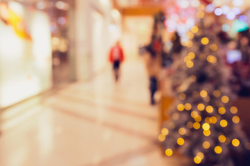 Abstract blurred and defocused background of shopping mall with bokeh. Christmas lights and garlands.