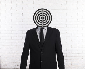 businessman obscuring face with darts board 