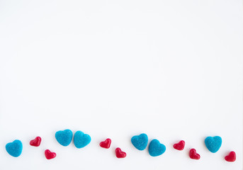 Valentines day card with tiny candy sweet blue, red  hearts on white background. Flat lay, top view, copy space. 