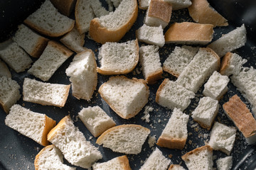 Finely diced dried bread. Finely chopped bread. Small pieces of bread. Square slices of bread. Rusks on a tray