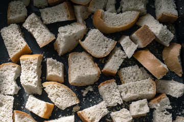 Finely diced dried bread. Finely chopped bread. Small pieces of bread. Square slices of bread. Rusks on a tray