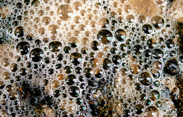 Wet granite after rain, covered with bubbles, texture of small stones.