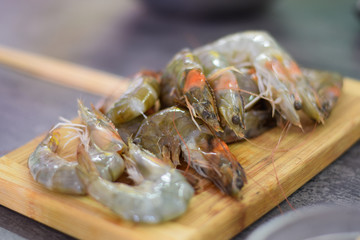 Raw Prawns laying on the wooden board close up