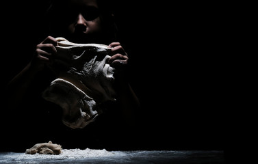 Little cute girl chef cooking with white flour on black background