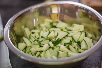 Raw sliced courgette in the metal bowl
