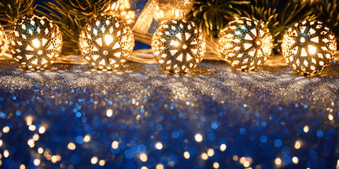 Christmas gold garland with fir tree on blue glitter. Copy space, frame.