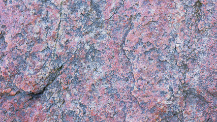 Texture of granite. Granite rock with reddish color. Background from solid stone. Pattern with natural material. Widescreen