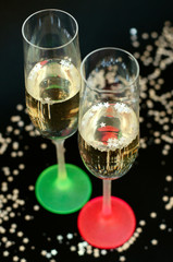 Two multi-colored neon glasses of champagne.