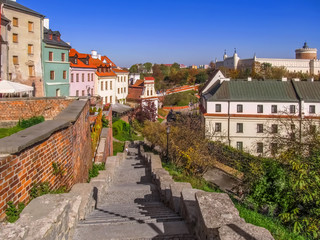 Beautiful autumn landscape of Lublin (Poland) with a castle on a hill. Colorful panorama of the town with colored houses, a stairs and motley trees © ioanna_alexa