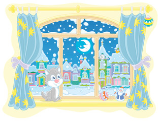 Little curious kitten sitting on a windowsill, looking through a window at the bright moon over a beautiful snow-covered town on a frosty winter night, vector cartoon illustration