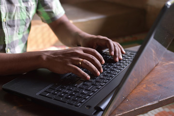 Cropped image of a young man working on his laptop .