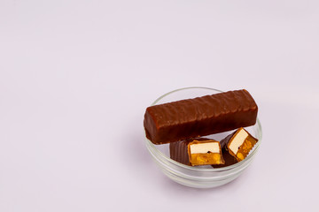 Chocolate bar on a white background. Chocolate-waffle bar with nut and caramel filling.